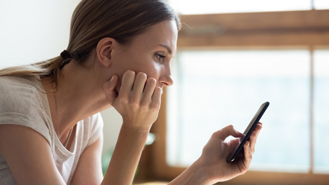 woman looking concerned at phone